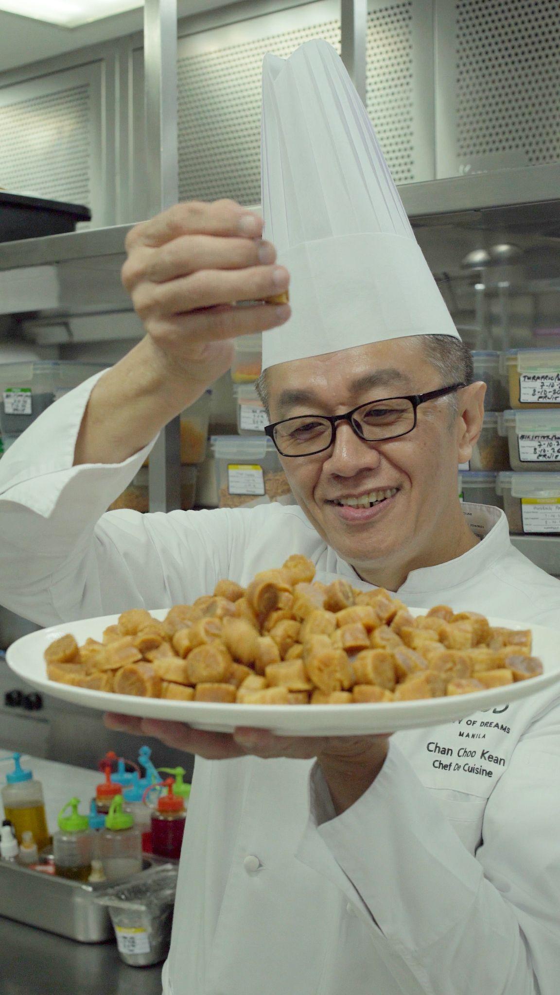 Chef Chan holding a platter of dried scallops