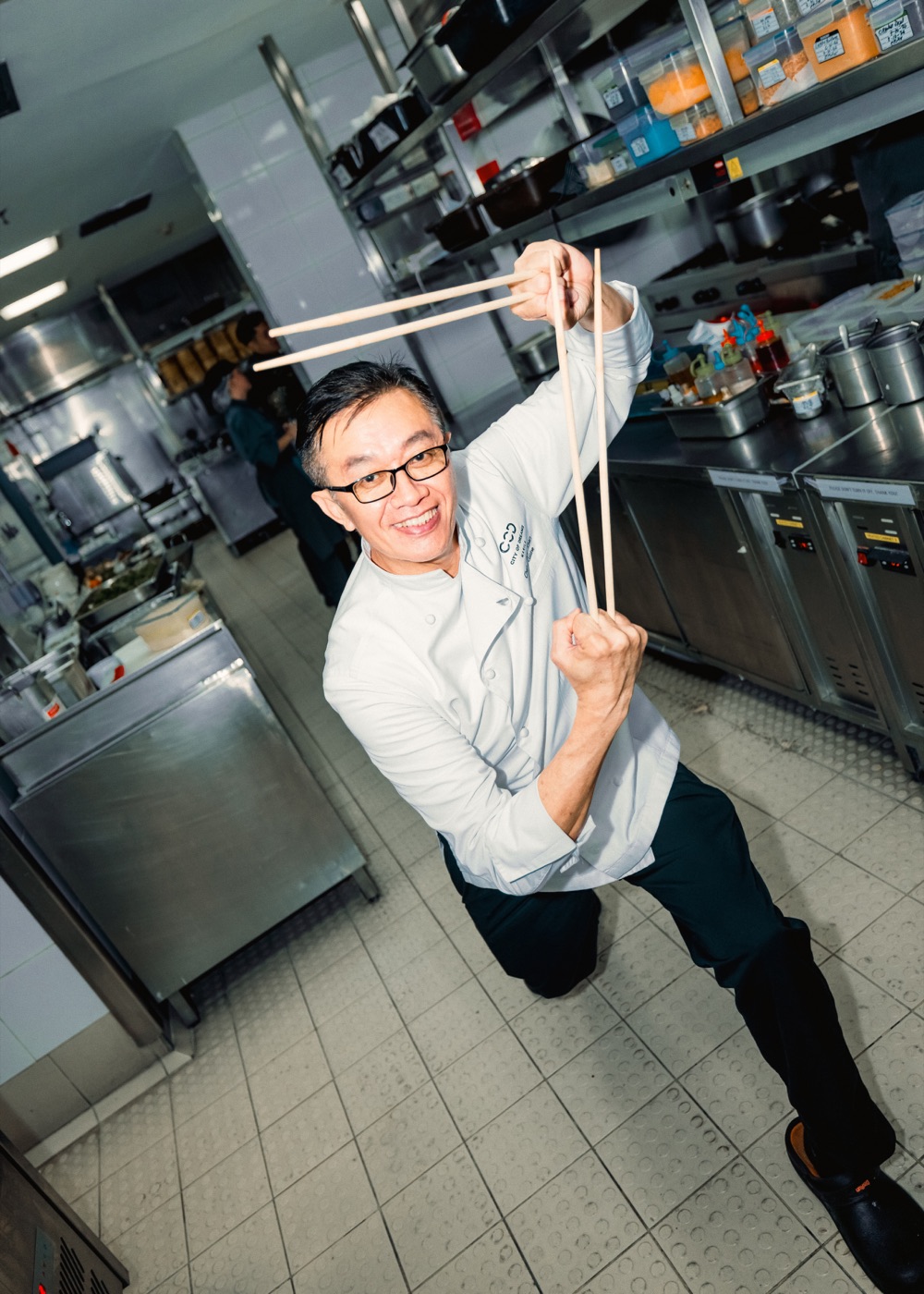 Chef Chan demonstrating a pair of long kitchen chopsticks