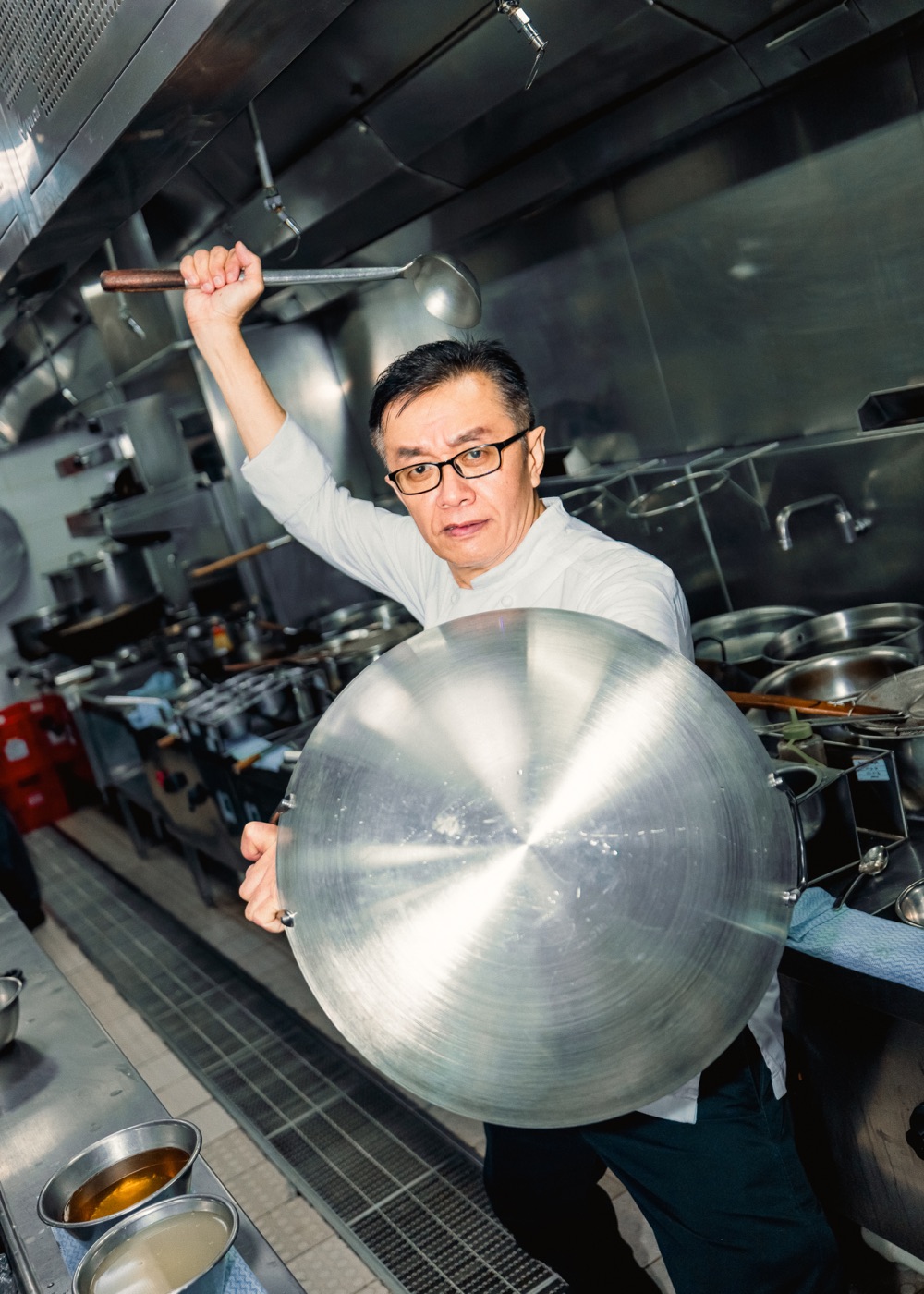 Chef Chan holding a wok in the Crystal Dragon kitchen