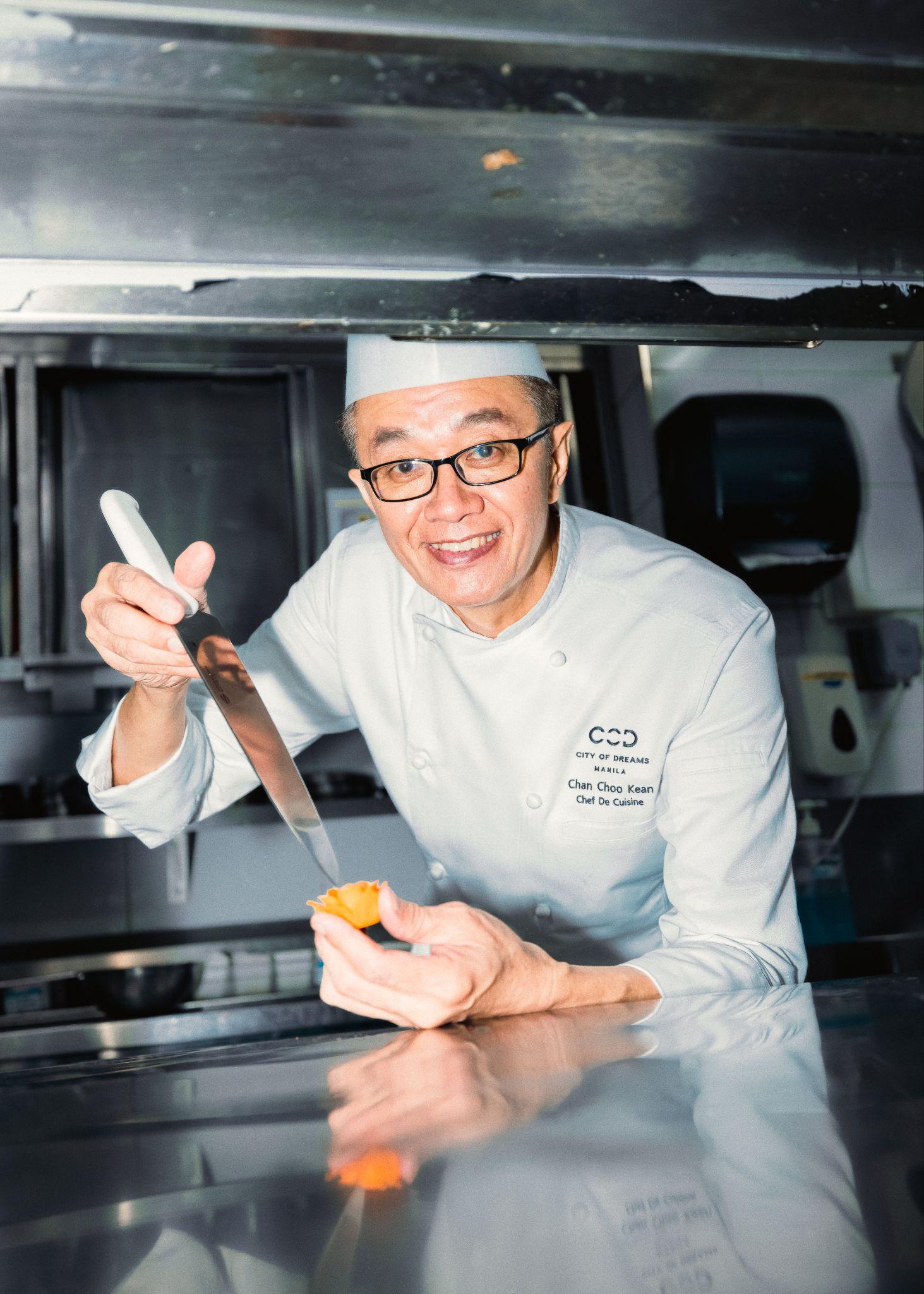 Chef Chan holding a carrot carved into a flower