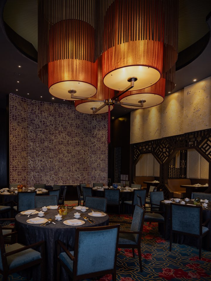 Crystal Dragon dining room with round tables and sculptural pendant lights